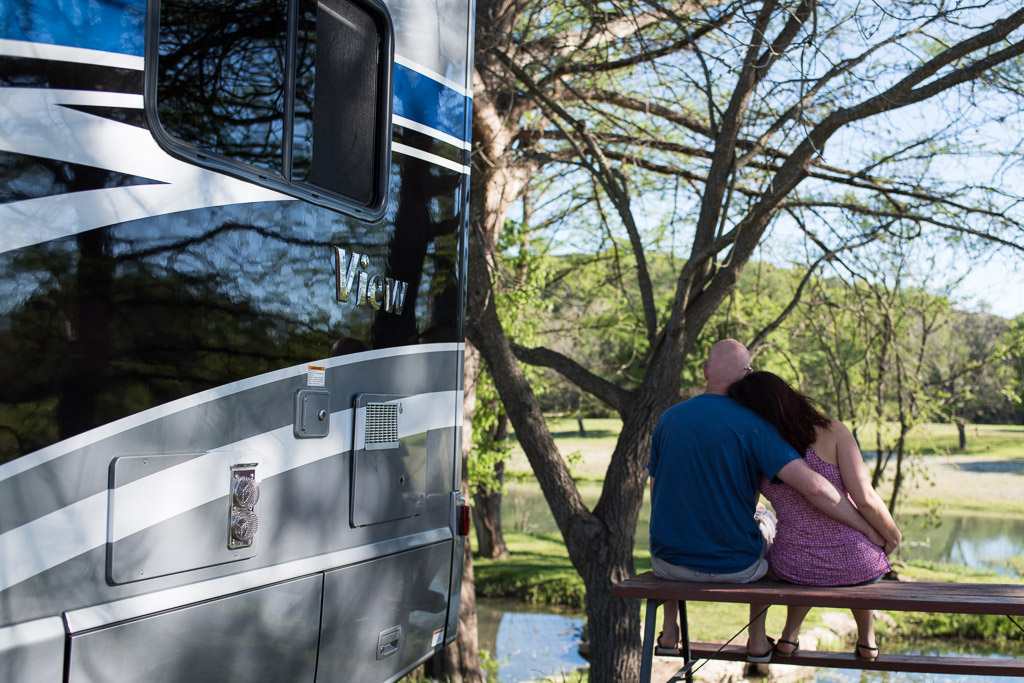 Couple sitting on a bench outside their Winnebago View.
