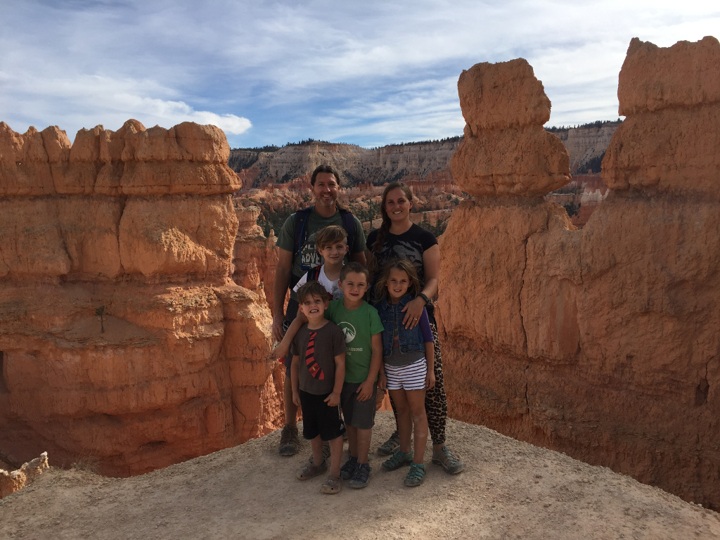 Family of 6 with unique rock formations and canyons surrounding them.