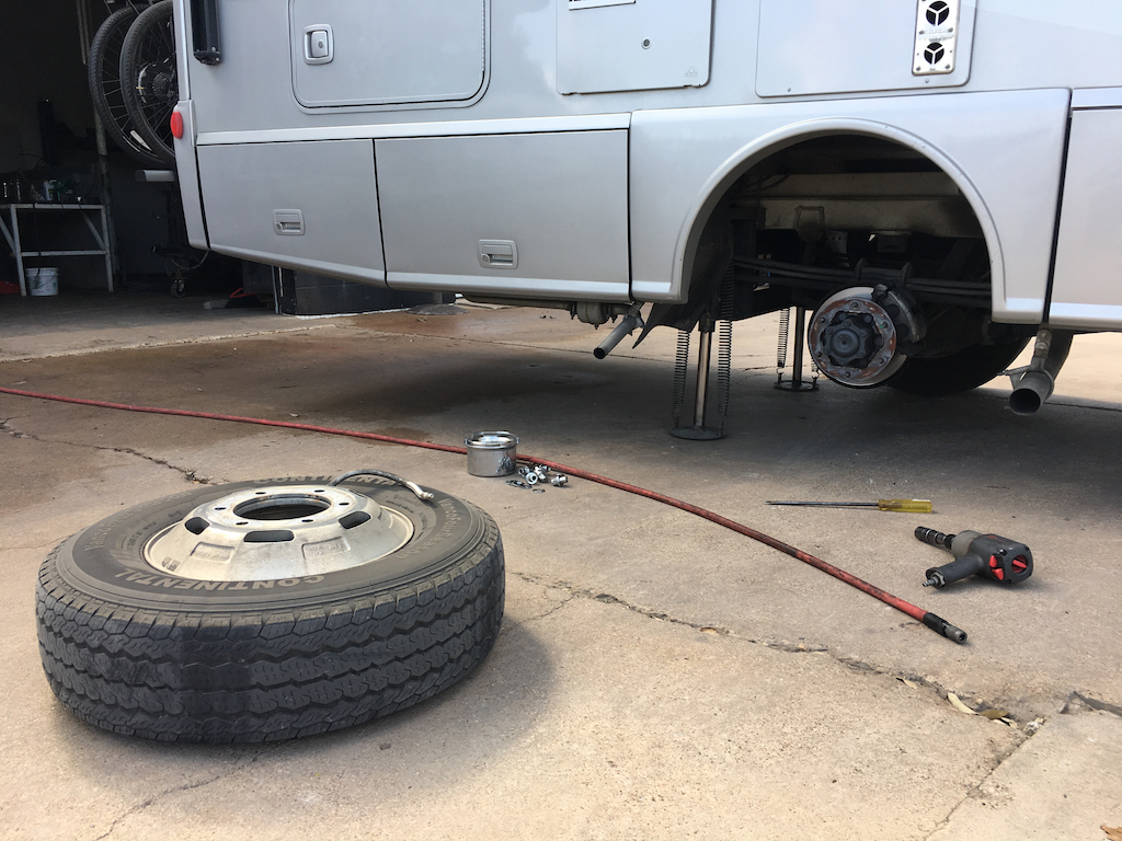 One of the rear Winnebago Navion tires sitting next to the motorhome.