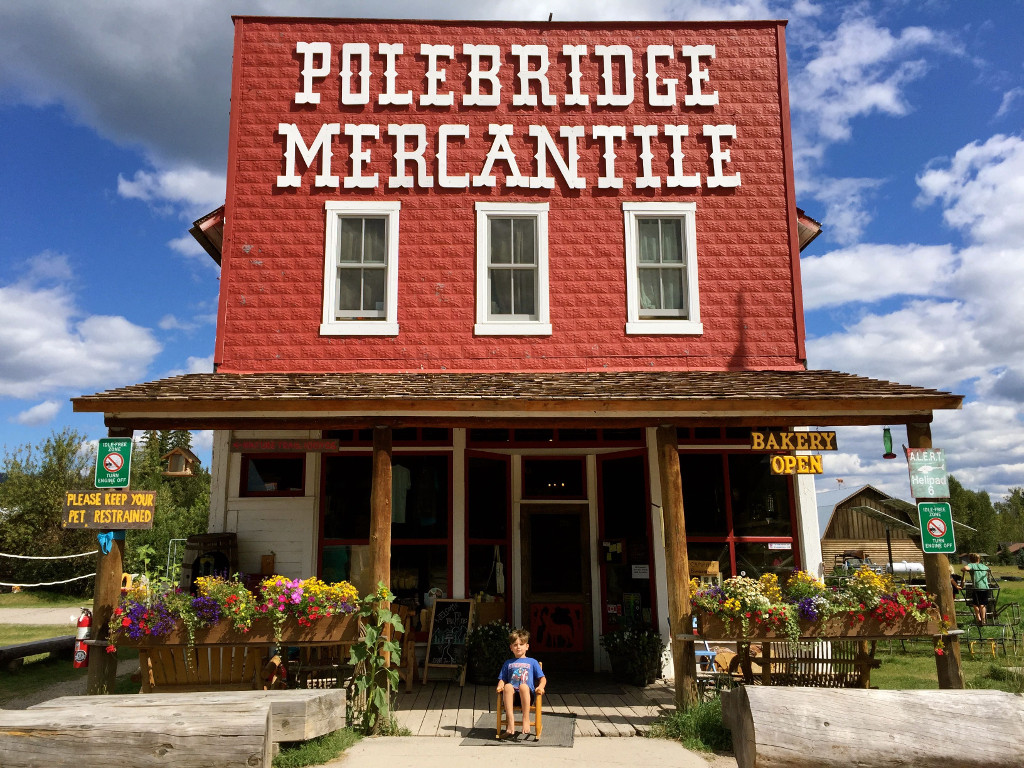 Child sitting in a small chair in front of Polebridge Mercantile store.
