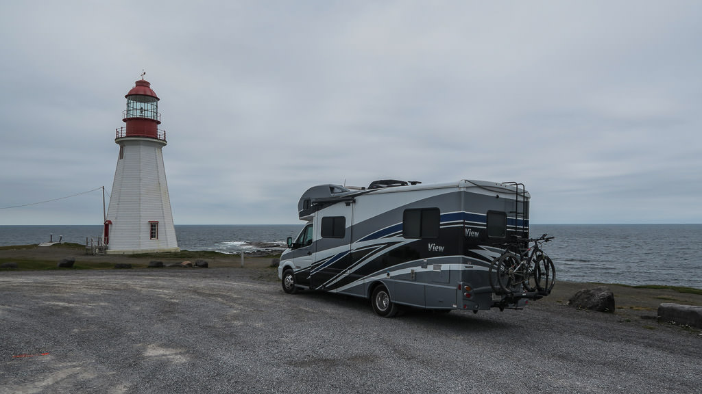 Winnebago View parked on the shore near a lighthouse