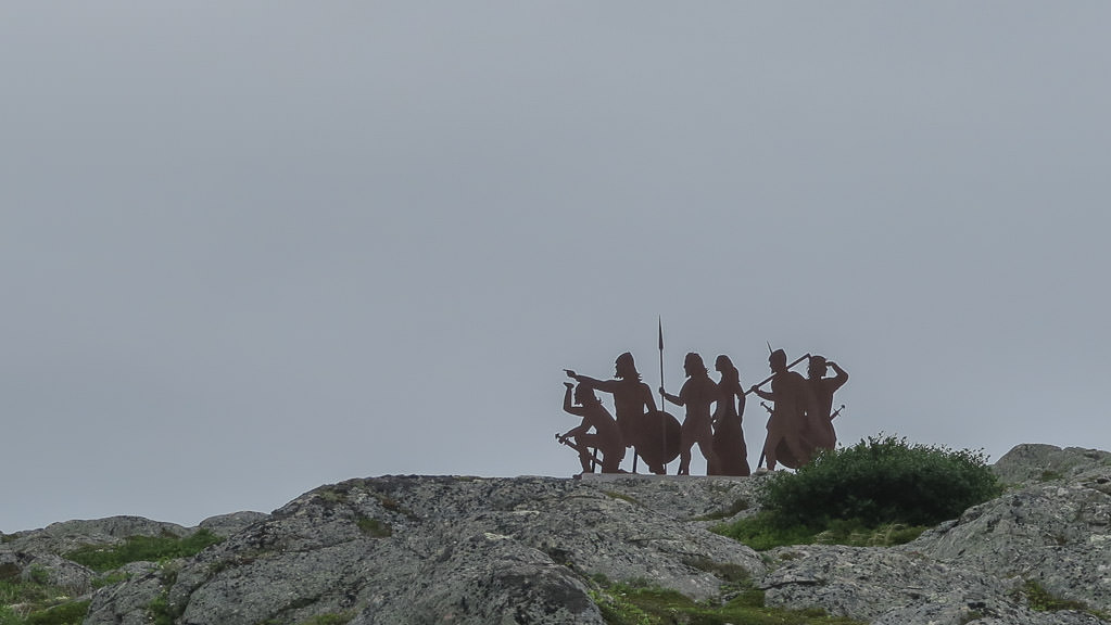 Art sculpture of natives atop rocky hill