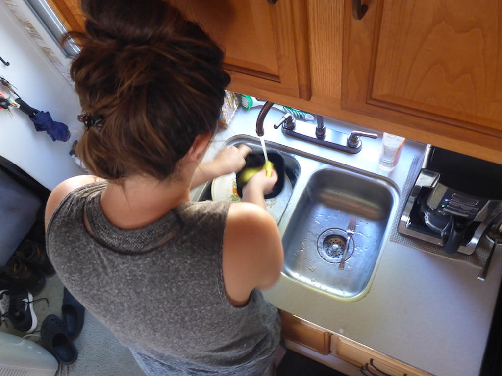 Melanie cleaning something in the sink.