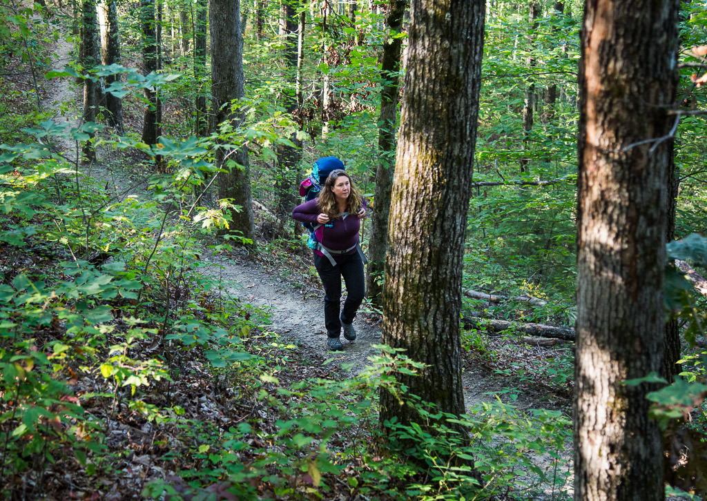 Kathy hiking along the narrow tree-lined trail.