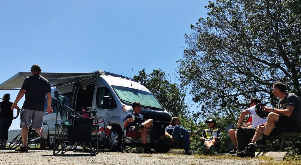 People gathered outside a camper van
