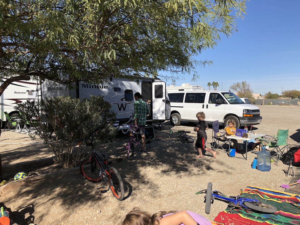 Winnebago Micro Minnie in campsite with kids outside playing among a small table and bikes.