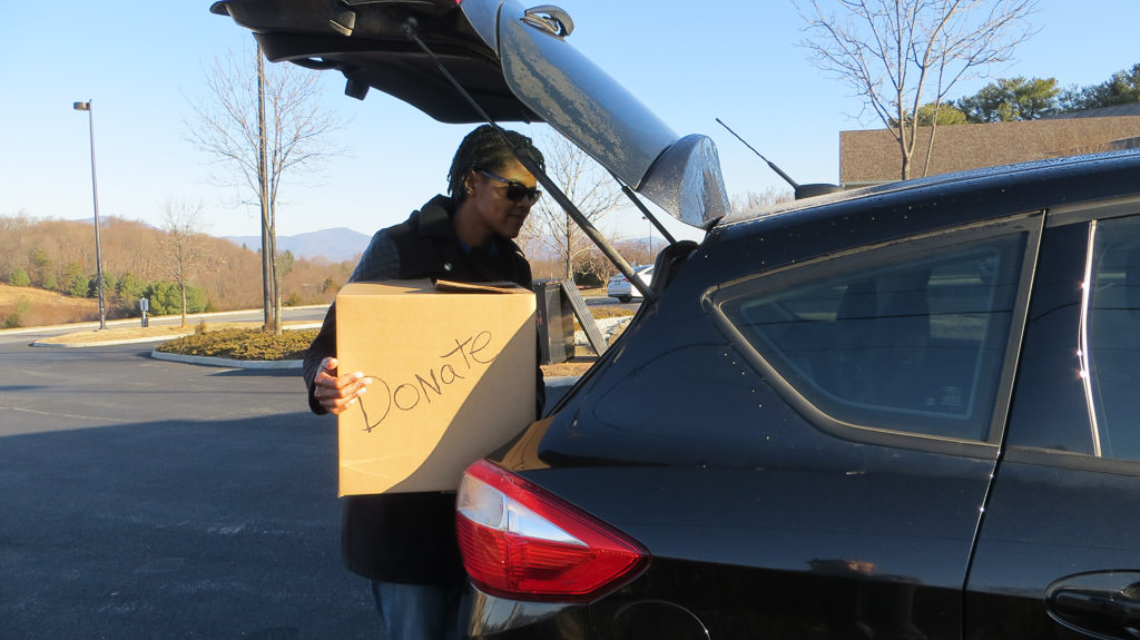 Sabrina putting a donation box in the back of car