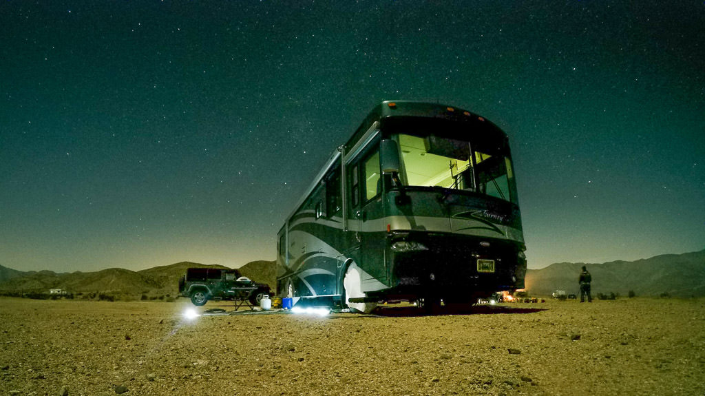 Winnebago Journey parked in desert with stars above