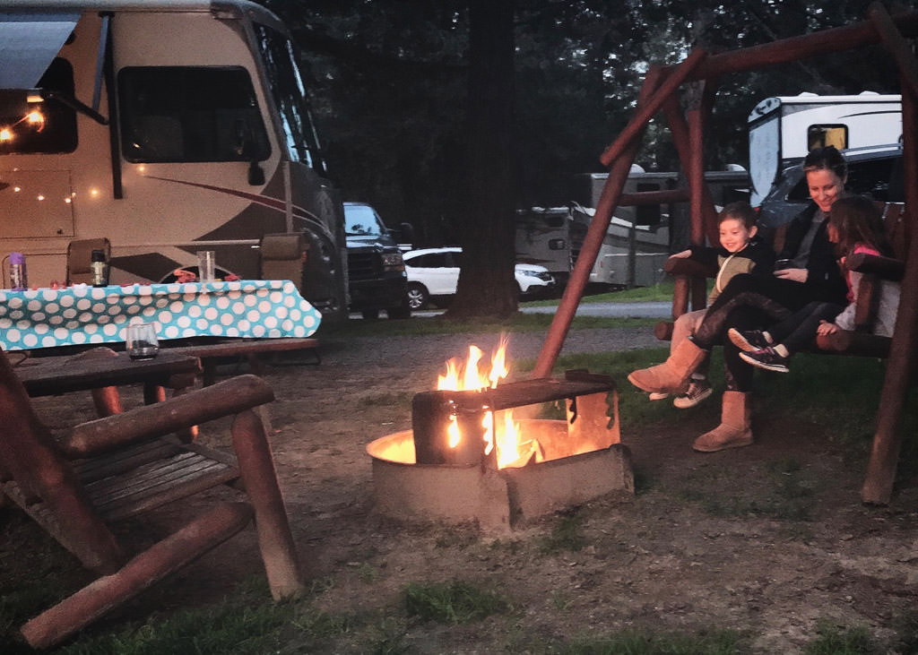 Karen and both children sitting next to campfire at night