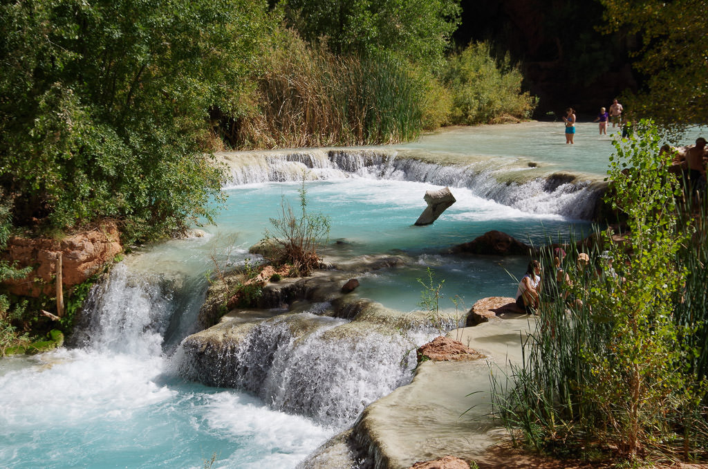 People in the water at the top of Havasu Falls