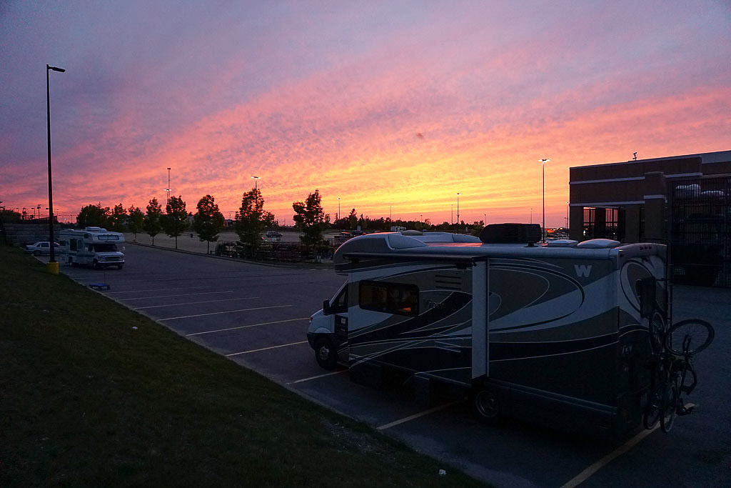 Winnebago View parked in Walmart parking lot with colorful sky in background