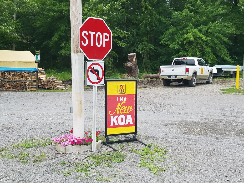 Stop sign that has standing sign by it that says "I'm a new KOA"