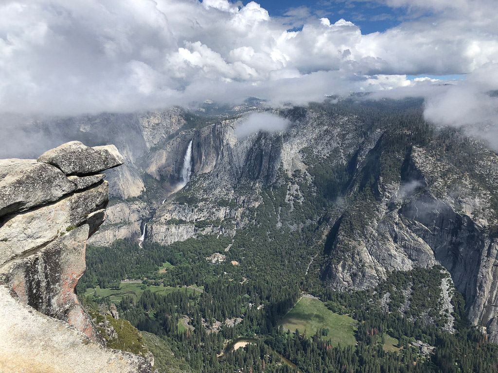 View from Glacier Point with waterfall, grassy and tree filled valley below