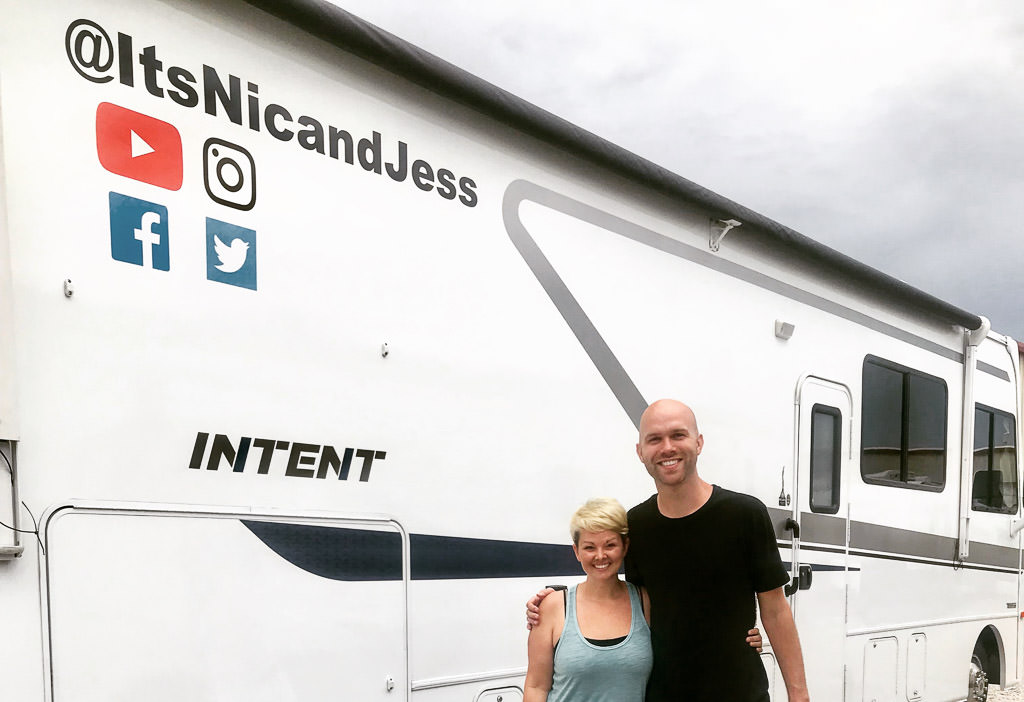 Nic and Jess standing outside their Winnebago Intent.