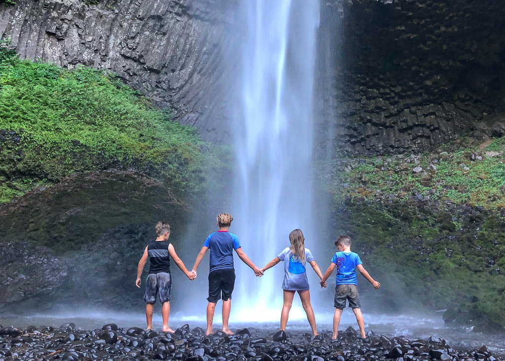 Kids standing in front of a waterfall
