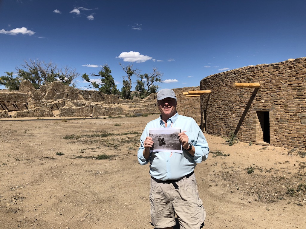 Don holding photo in front of ruins in Aztec, NM