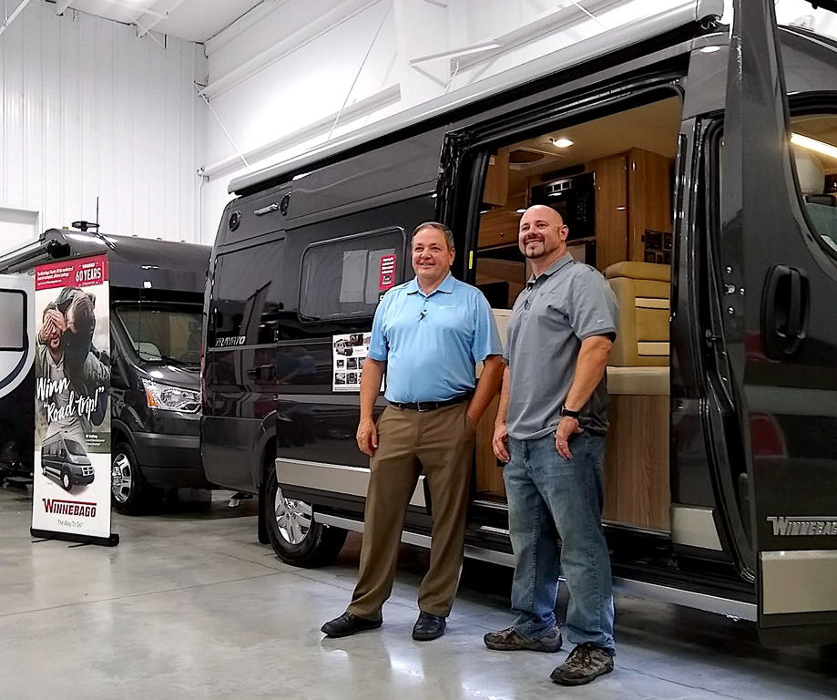 Russ Garfin and Kenny standing in front of Winnebago Travato on display at Open House.
