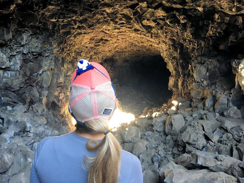 Stef wearing a headlamp looking down tunnel