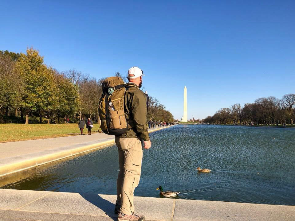 Person standing in front of memorial wearing Warrior Expeditions gear