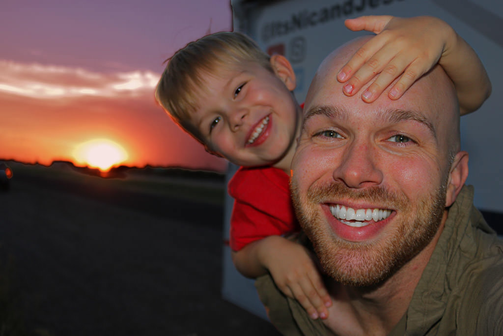 Nic and one of their boys with sun setting in the background