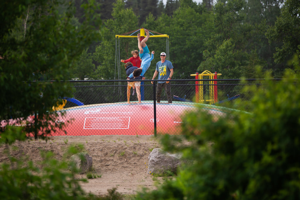 Kids playing on a jumping pad at the playground.