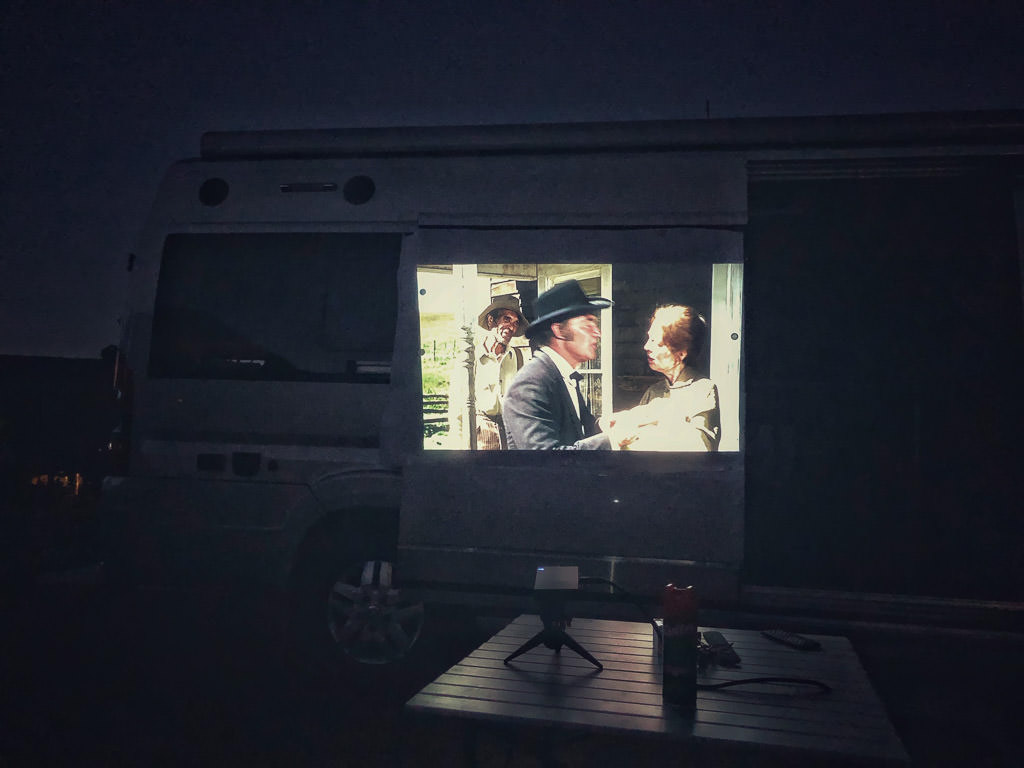 Outdoor movie projection screen applied to Winnebago Travato for outdoor movie night