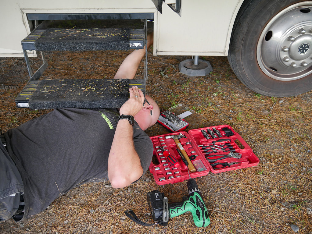 A man repairing Quickie steps on his Winnebago Vista