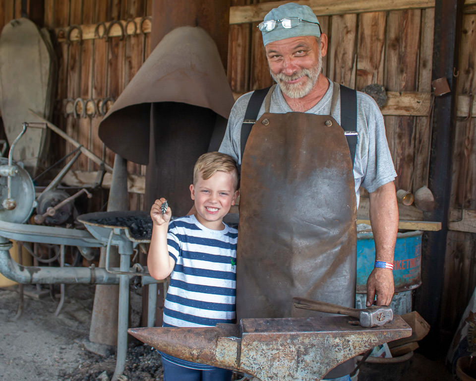 Child with blacksmith at the Heritage Festival