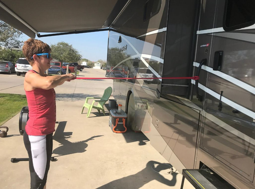 Woman uses RV for band resistant training in her "mobile RV gym"